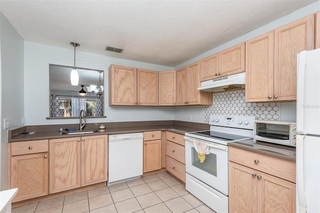 89 Fremont Ave Unit 504, Daytona Beach, FL 32114 - kitchen with under cabinet range hood, white appliances, light brown cabinetry, dark countertops, and light tile patterned floors
