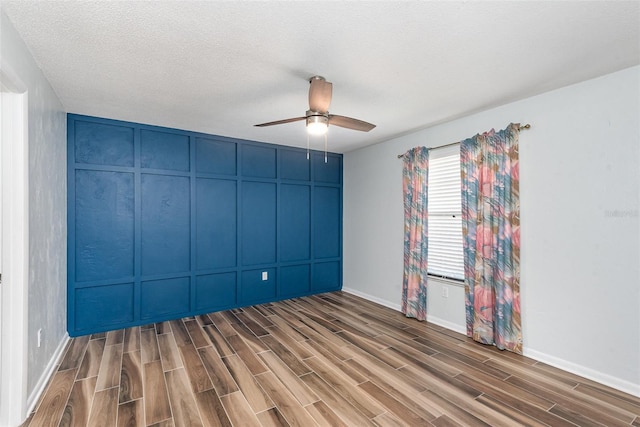 89 Fremont Ave Unit 504, Daytona Beach, FL 32114 - unfurnished room with wood finished floors, ceiling fan, a textured ceiling, and a decorative wall