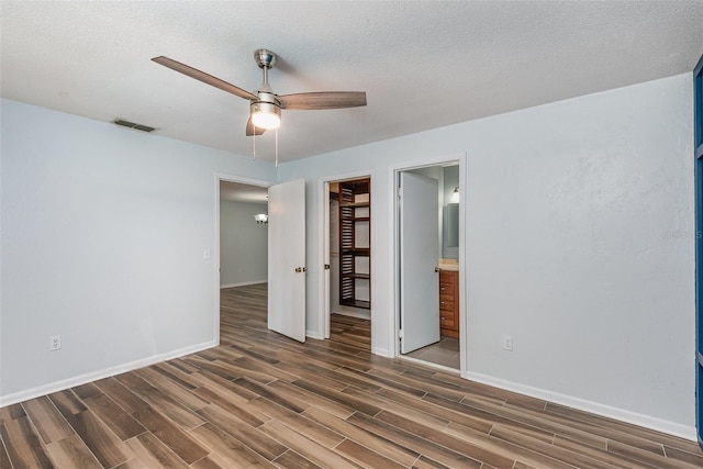 89 Fremont Ave Unit 504, Daytona Beach, FL 32114 - unfurnished bedroom featuring wood finished floors, a walk in closet, a closet, connected bathroom, and a ceiling fan