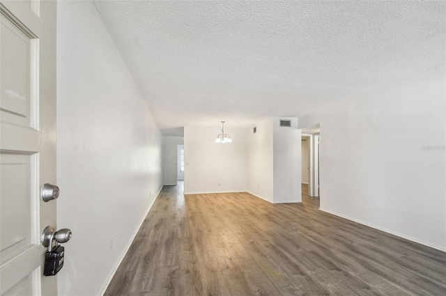 2310 Denmark St Unit 34, Clearwater, FL 33763 - spare room with a chandelier, wood finished floors, and a textured ceiling