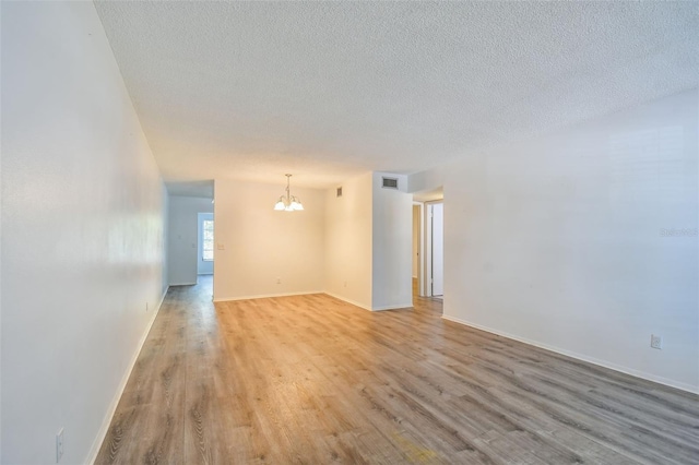 2310 Denmark St Unit 34, Clearwater, FL 33763 - unfurnished room with a chandelier, light wood finished floors, and a textured ceiling