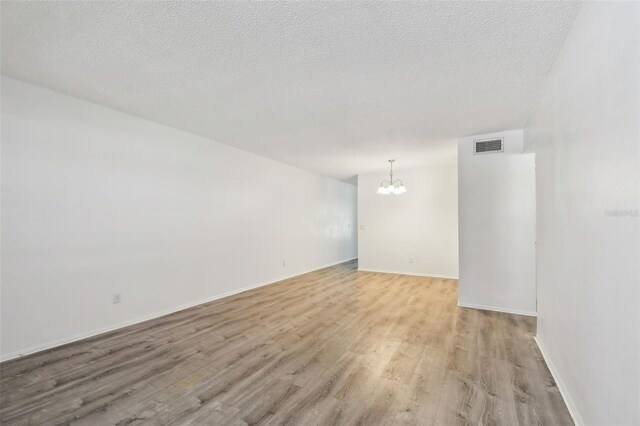 2310 Denmark St Unit 34, Clearwater, FL 33763 - spare room with a chandelier, light wood-type flooring, and a textured ceiling