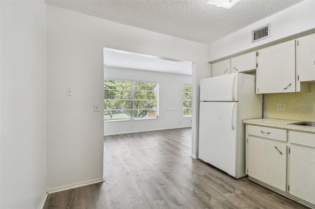2310 Denmark St Unit 34, Clearwater, FL 33763 - kitchen featuring freestanding refrigerator, wood finished floors, light countertops, and a textured ceiling
