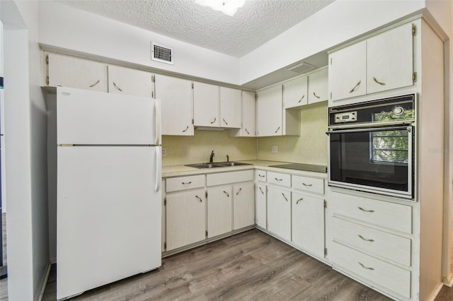 2310 Denmark St Unit 34, Clearwater, FL 33763 - kitchen featuring black appliances, a textured ceiling, wood finished floors, and light countertops