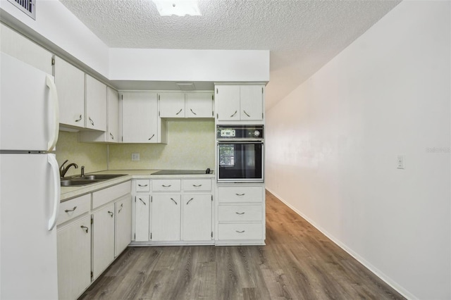 2310 Denmark St Unit 34, Clearwater, FL 33763 - kitchen with black appliances, a textured ceiling, dark wood finished floors, and light countertops