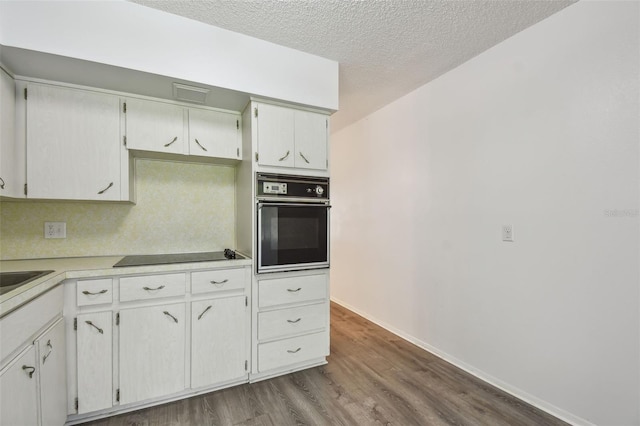 2310 Denmark St Unit 34, Clearwater, FL 33763 - kitchen featuring black appliances, dark wood-style flooring, a textured ceiling, and light countertops