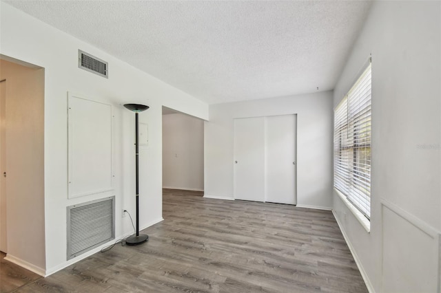 2310 Denmark St Unit 34, Clearwater, FL 33763 - unfurnished bedroom featuring a textured ceiling, a closet, and wood finished floors