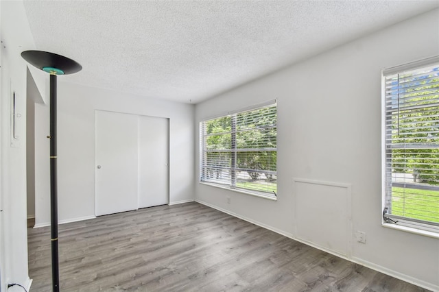 2310 Denmark St Unit 34, Clearwater, FL 33763 - unfurnished bedroom featuring a textured ceiling, wood finished floors, and a closet