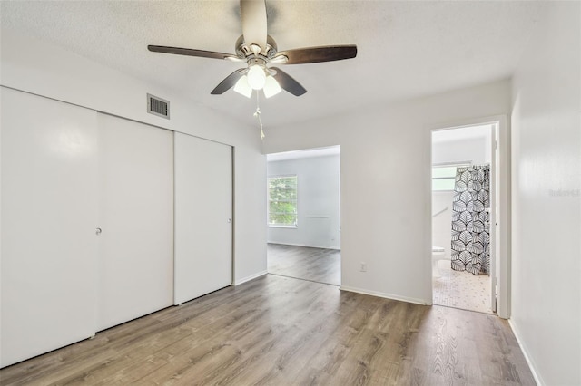 2310 Denmark St Unit 34, Clearwater, FL 33763 - unfurnished bedroom with wood finished floors, a closet, ensuite bathroom, and ceiling fan