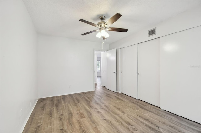 2310 Denmark St Unit 34, Clearwater, FL 33763 - unfurnished bedroom featuring wood finished floors, a closet, a ceiling fan, and a textured ceiling