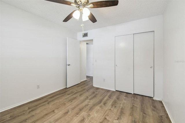 2310 Denmark St Unit 34, Clearwater, FL 33763 - unfurnished bedroom featuring wood finished floors, a closet, a ceiling fan, and a textured ceiling