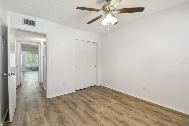 2310 Denmark St Unit 34, Clearwater, FL 33763 - unfurnished bedroom featuring wood finished floors, a closet, a ceiling fan, and a textured ceiling