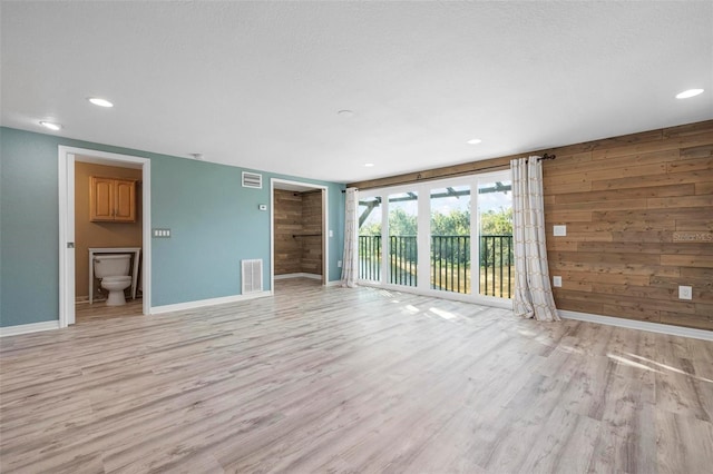 6814 68th Ave E, Bradenton, FL 34203 - unfurnished living room with light wood-style floors, recessed lighting, and wood walls