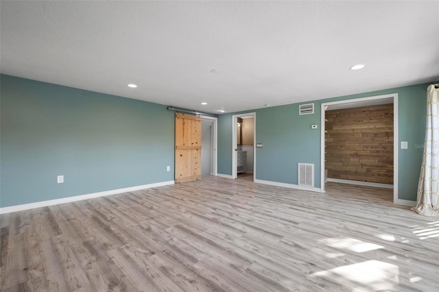 6814 68th Ave E, Bradenton, FL 34203 - spare room featuring recessed lighting, light wood finished floors, and a barn door