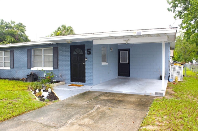 5 Moonlight Ln, Winter Haven, FL 33884 - ranch-style house with an attached carport, concrete driveway, and brick siding