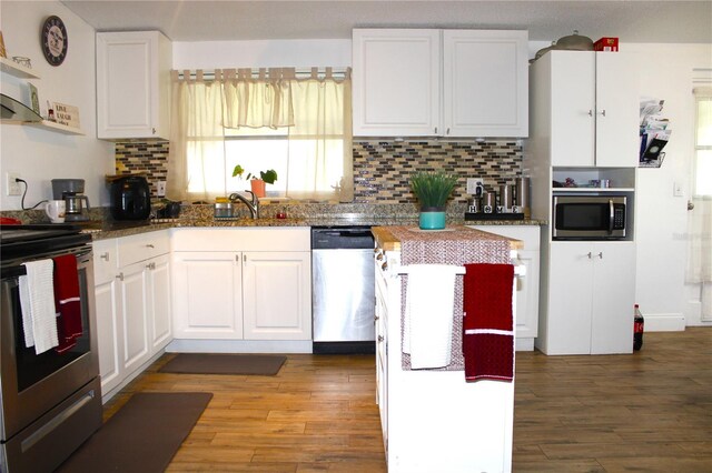 5 Moonlight Ln, Winter Haven, FL 33884 - kitchen with stainless steel appliances, white cabinets, and wood finished floors