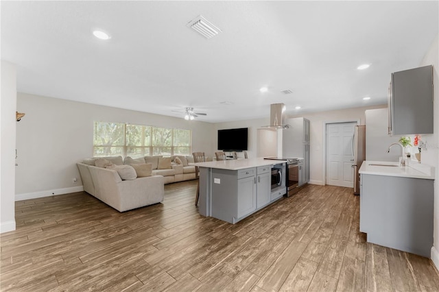9819 Allen Rd, Lithia, FL 33547 - kitchen featuring stainless steel appliances, gray cabinets, light countertops, ventilation hood, and recessed lighting