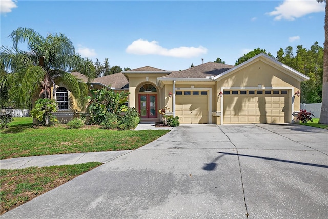 1835 Fircrest Ct, Wesley Chapel, FL 33543 - view of front of house featuring an attached garage, stucco siding, driveway, a front lawn, and french doors