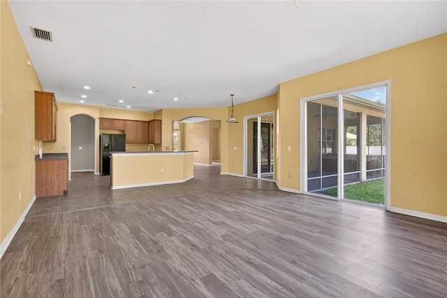 1835 Fircrest Ct, Wesley Chapel, FL 33543 - unfurnished living room featuring arched walkways, dark wood-type flooring, and recessed lighting
