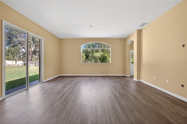 1835 Fircrest Ct, Wesley Chapel, FL 33543 - empty room with arched walkways and dark wood finished floors
