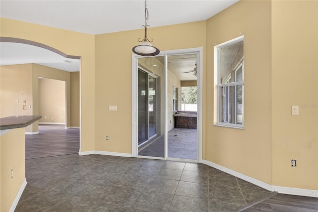 1835 Fircrest Ct, Wesley Chapel, FL 33543 - empty room with arched walkways and dark tile patterned flooring
