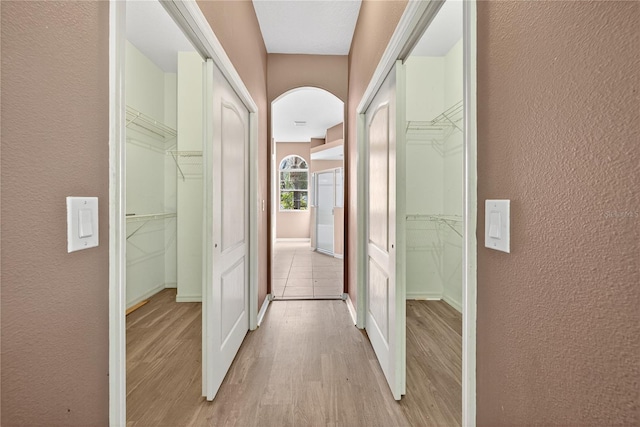 1835 Fircrest Ct, Wesley Chapel, FL 33543 - corridor featuring a textured wall, light wood-type flooring, and arched walkways