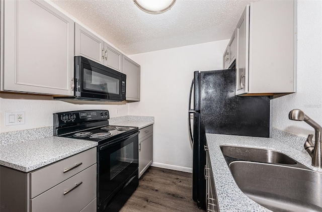 8184 49th Ave N, Saint Petersburg, FL 33709 - kitchen featuring black appliances, dark wood-style flooring, gray cabinetry, light countertops, and a textured ceiling