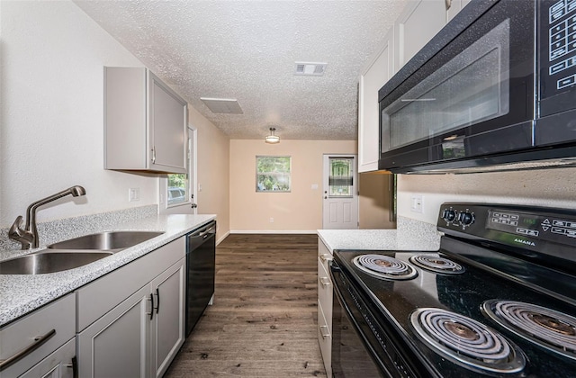 8184 49th Ave N, Saint Petersburg, FL 33709 - kitchen with black appliances, dark wood-style floors, a textured ceiling, gray cabinetry, and light countertops