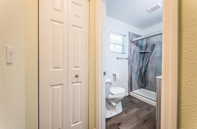 8184 49th Ave N, Saint Petersburg, FL 33709 - bathroom with a closet, wood finished floors, a shower stall, and a textured ceiling