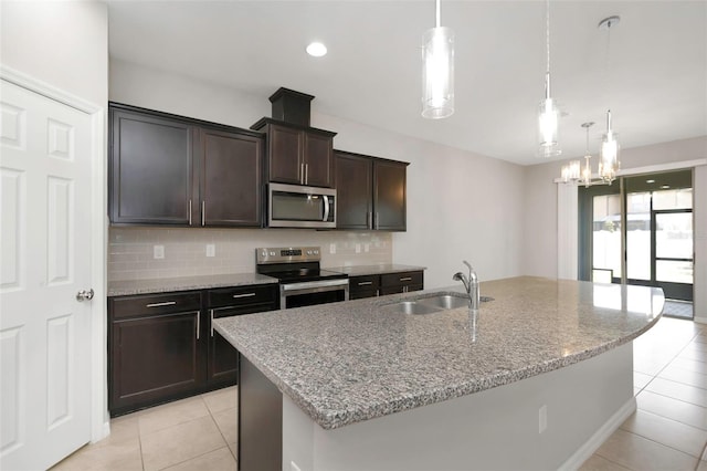 1613 Cabbage Key Dr, Ruskin, FL 33570 - kitchen with stainless steel appliances, light tile patterned flooring, backsplash, light stone countertops, and dark brown cabinets