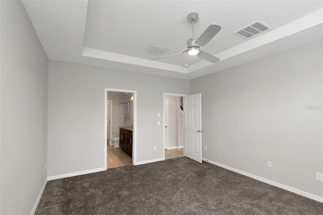1613 Cabbage Key Dr, Ruskin, FL 33570 - unfurnished bedroom featuring a raised ceiling, carpet flooring, connected bathroom, and a ceiling fan