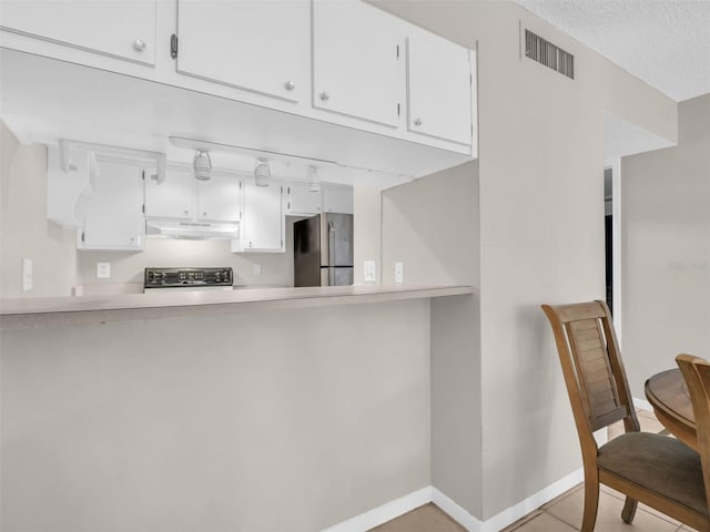 401 Windrush Bay Dr, Tarpon Springs, FL 34689 - kitchen with freestanding refrigerator, under cabinet range hood, range, and white cabinetry