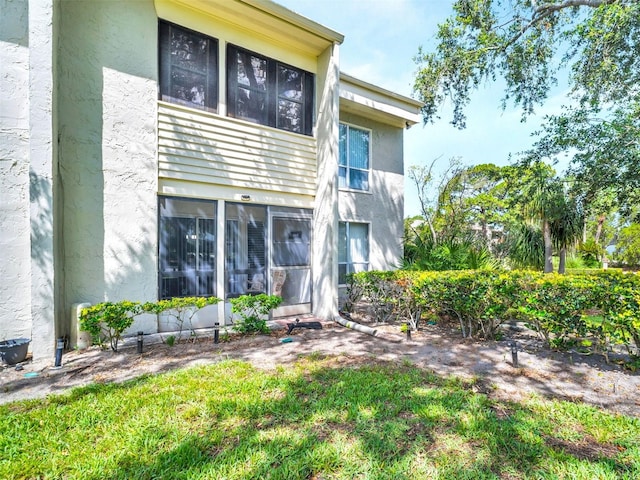 401 Windrush Bay Dr, Tarpon Springs, FL 34689 - back of property with stucco siding and a sunroom