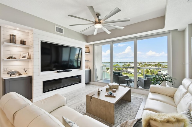415 Island Way Unit 507, Clearwater Beach, FL 33767 - living area with a ceiling fan and a glass covered fireplace