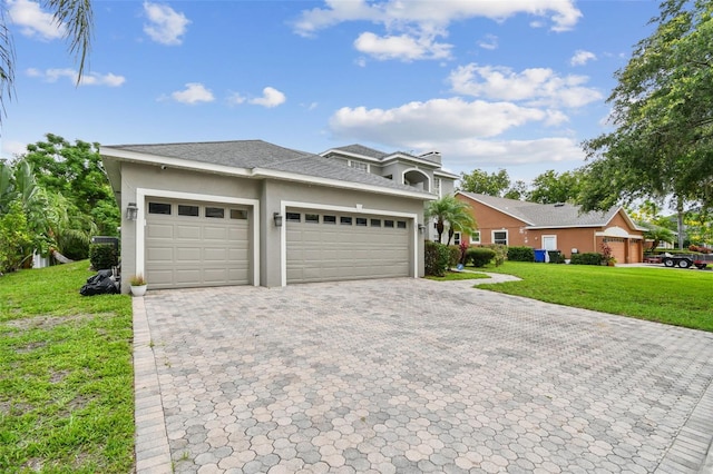 297 Beacon Pointe Dr, Ocoee, FL 34761 - view of front of home featuring stucco siding, decorative driveway, an attached garage, and a front lawn