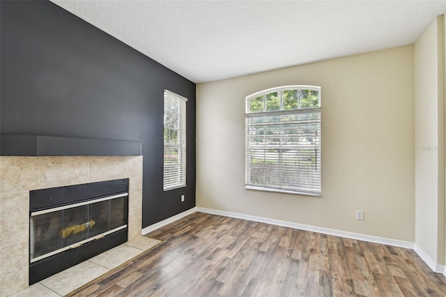 297 Beacon Pointe Dr, Ocoee, FL 34761 - unfurnished living room with wood finished floors, a fireplace, and a textured ceiling
