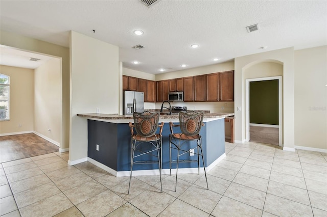 297 Beacon Pointe Dr, Ocoee, FL 34761 - kitchen with stainless steel appliances, a kitchen breakfast bar, light stone countertops, recessed lighting, and a peninsula