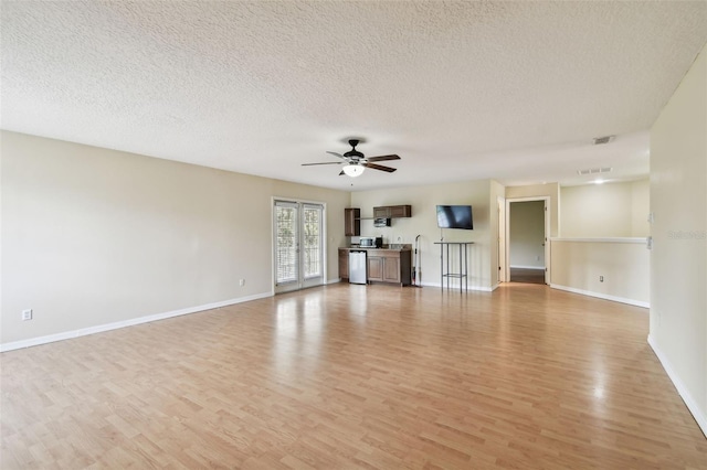 297 Beacon Pointe Dr, Ocoee, FL 34761 - unfurnished living room with light wood finished floors, a ceiling fan, and a textured ceiling