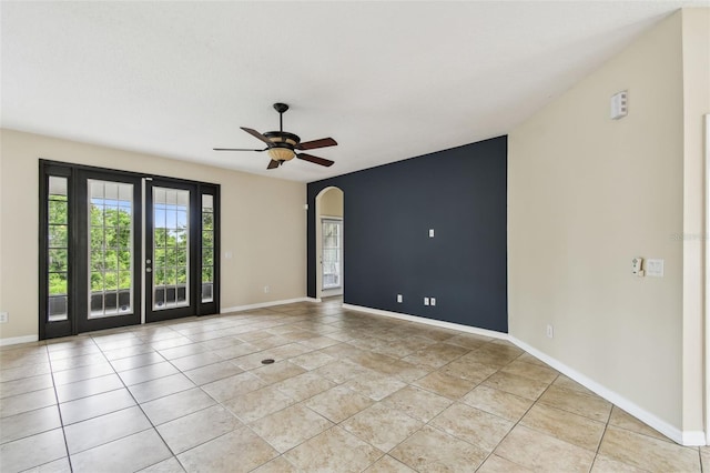 297 Beacon Pointe Dr, Ocoee, FL 34761 - empty room with arched walkways, a ceiling fan, and light tile patterned flooring