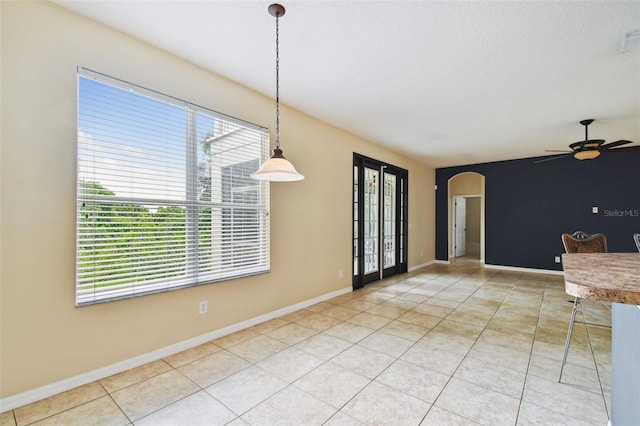 297 Beacon Pointe Dr, Ocoee, FL 34761 - unfurnished dining area with arched walkways, ceiling fan, and tile patterned floors
