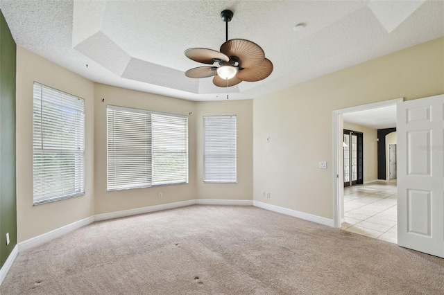 297 Beacon Pointe Dr, Ocoee, FL 34761 - unfurnished room with light carpet, a ceiling fan, a tray ceiling, a textured ceiling, and a smoke detector