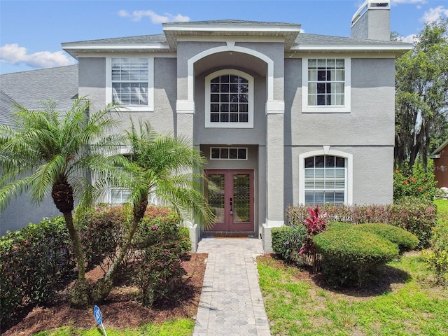 297 Beacon Pointe Dr, Ocoee, FL 34761 - view of front of property with french doors, stucco siding, and a chimney