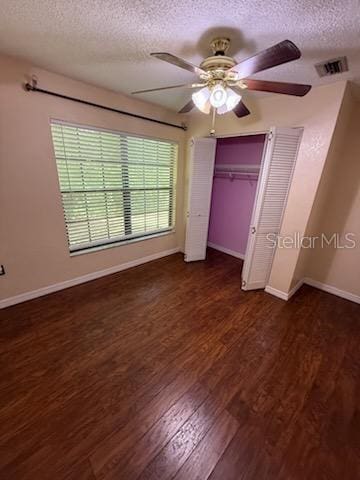 1020 85th Ave N Unit 223, Saint Petersburg, FL 33702 - unfurnished bedroom with a textured ceiling, dark wood-style floors, a ceiling fan, and a closet