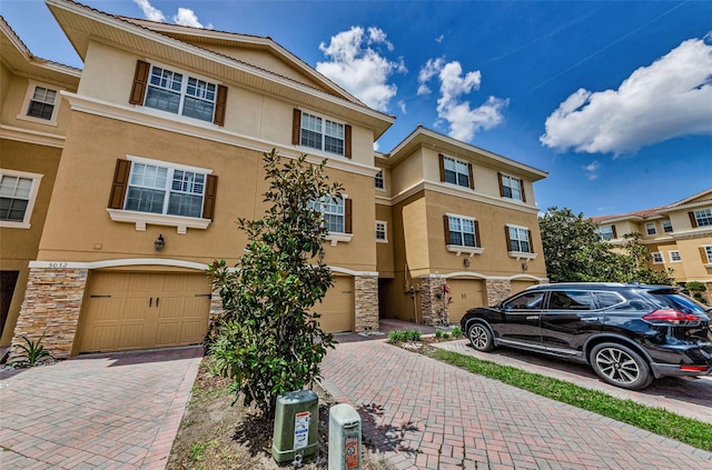 5030 Herring Ct, New Port Richey, FL 34652 - view of property with stone siding, stucco siding, and an attached garage
