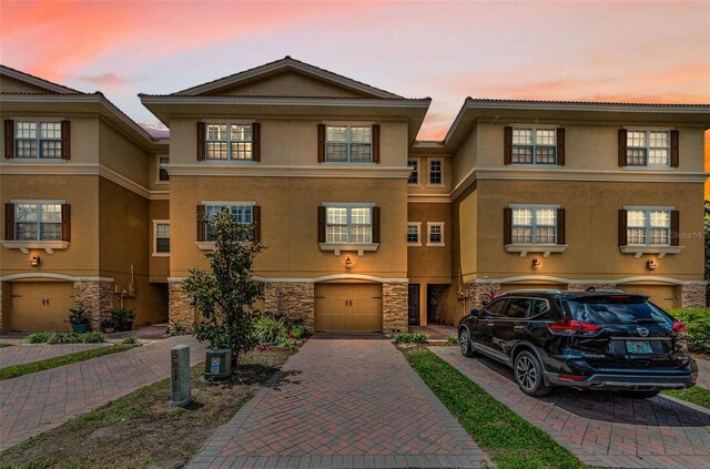 5030 Herring Ct, New Port Richey, FL 34652 - townhome / multi-family property featuring driveway, a garage, stucco siding, and stone siding