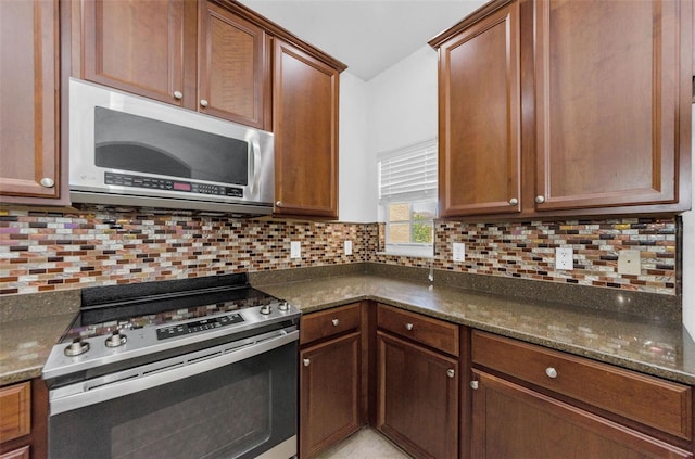 5030 Herring Ct, New Port Richey, FL 34652 - kitchen featuring appliances with stainless steel finishes, backsplash, dark stone countertops, and brown cabinetry