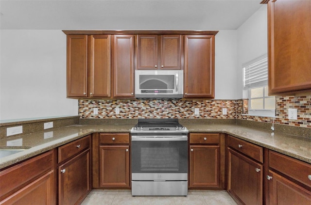 5030 Herring Ct, New Port Richey, FL 34652 - kitchen with stainless steel appliances, tasteful backsplash, dark stone countertops, and light tile patterned floors