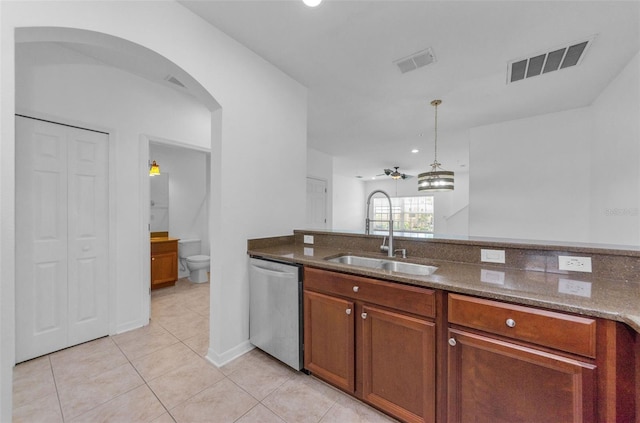 5030 Herring Ct, New Port Richey, FL 34652 - kitchen with dishwasher, light tile patterned floors, dark stone countertops, and arched walkways