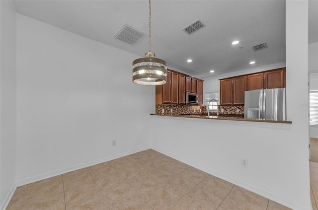 5030 Herring Ct, New Port Richey, FL 34652 - kitchen with appliances with stainless steel finishes, recessed lighting, decorative backsplash, dark countertops, and decorative light fixtures