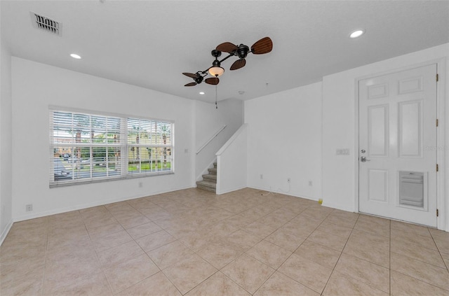 5030 Herring Ct, New Port Richey, FL 34652 - empty room with a ceiling fan, stairs, recessed lighting, and light tile patterned flooring